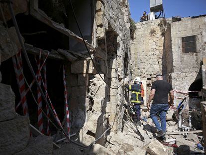 Una persona busca supervivientes en una vivienda de Gaza atacada por Israel donde murieron tres personas.