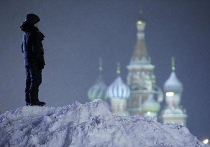 Un nen sobre un monticle de neu davant de la catedral de Sant Basili, a la plaça Roja de Moscou, Rússia.