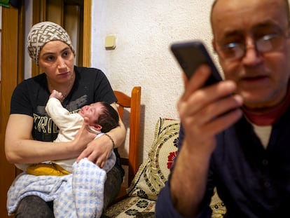 Rachid El Yagoubi trata de evitar que les desahucien mientras su mujer, Fátima Maknassi, le observa, con el cuarto hijo de ambos, Amir, de un mes, en los brazos.