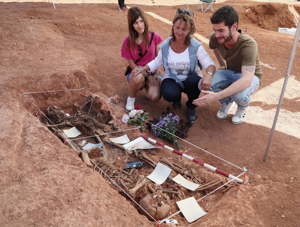 Lucia Rodrigo, nieta de Alberto Rodrigo, junto a su hija Vanesa y su sobrino David, junto a dos de los cuatro cadáveres exhumados.