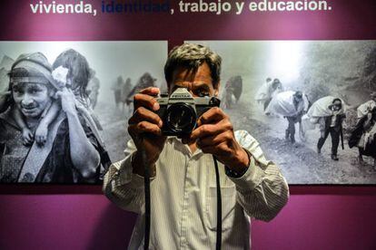 El fotógrafo José Rodríguez posa frente a imágenes de desplazados.