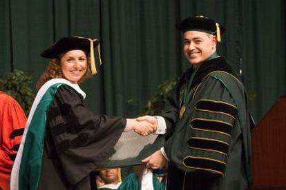 Cabrera entrega un diploma a una de las graduadas por la George Mason en 2012.
