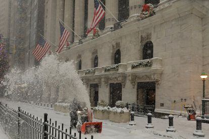 Un trabajador despeja la nieve frente a la Bolsa de Nueva York (EE UU).