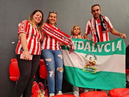 Joaquín Garnica junto a su mujer y sus dos hijos vistiendo la camiseta del Athletic Club y mostrando una bandera de Andalucía.