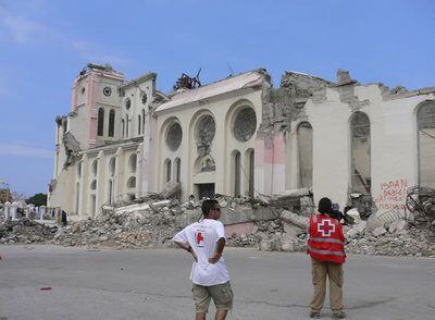 Cooperantes de Cruz Roja Española ante la Catedral derruída de Haití