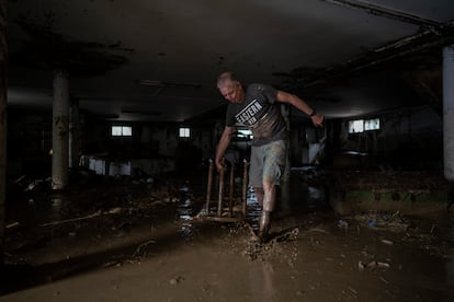 Marco saca una mesa de un garaje lleno de agua y barro.
