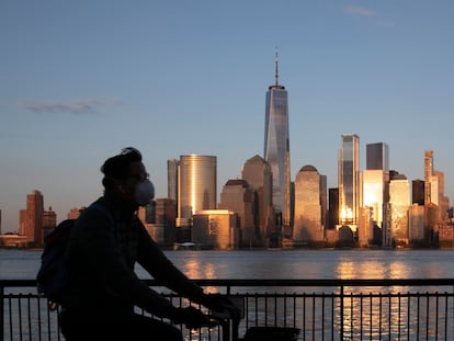 Un hombre camina por una calle desierta ante el 'skyline 'de Manhattan.