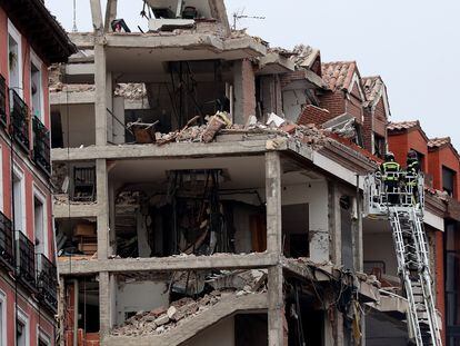 Dos bomberos trabajan en el inmueble afectado por la explosión en la calle de Toledo.