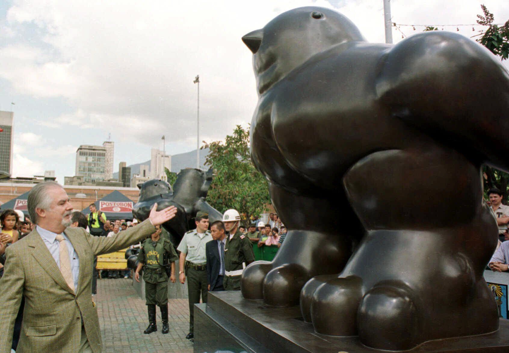 El 10 de junio de 1995, la explosión de una bomba en el parque San Antonio de Medellin se cobró la vida de 26 personas y desturyó la escultura titulada 'El pájaro' de Fernando Botero. Los restos de esta obra quedaron como un monumento desfigurado, y al lado, el artista hizo otra paloma como homenaje a la paz. Así sigue hoy en día. La guerra y la paz de Colombia a través de su artista más universal. En la imagen, Botero presenta su segunda paloma, junto a la que fue destruída por la bomba, el 5 de enero de 2000. 