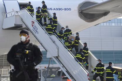 Un equipo de bomberos en Praga descarga cajas con material protector enviado por China