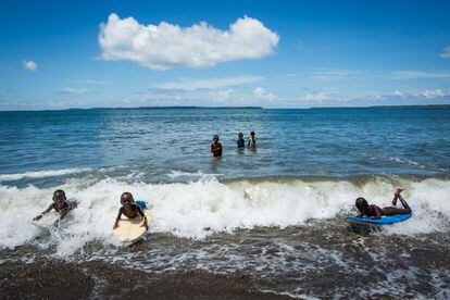 Niños jugando con tablas de surf rotas en la aldea de Colpakisa.