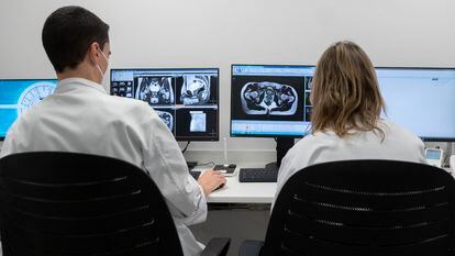 Dos técnicos controlan el único sistema de radioterapia de precisión molecular guiado por resonancia magnética de España, en el Hospital Carlos III, en diciembre de 2021.