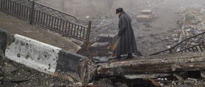 Una mujer cruza el pasado marzo un puente destruido tras un bombardeo aéreo en Donetsk, en el este de Ucrania.