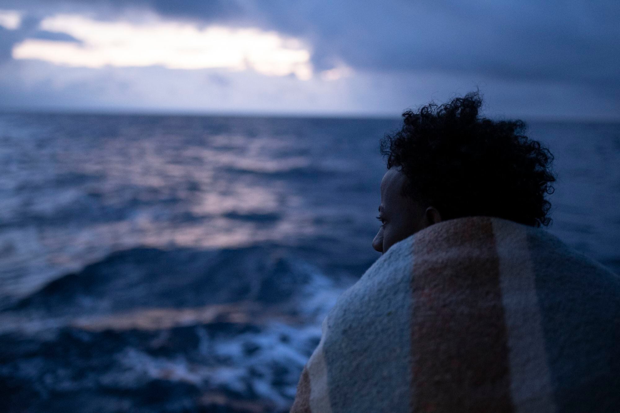 Un joven contempla el amanecer en la cubierta del Open Arms. Él es uno de los integrantes de la primera embarcación rescatada por la ONG española durante la Misión 107, unos días después de Navidad.