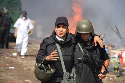 Dos policías se alejan del campamento establecido por los partidarios del presidente derrocado islamista Mohamed Morsi en Nasr City distrito, El Cairo, Egipto.