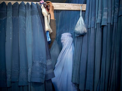 Una afgana espera en el probador de una tienda para probarse un burka en Kabul, Afganistán, el 11 de abril de 2013.