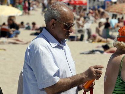 Una pareja de ancianos en la playa de El Postiguet, en Alicante. 