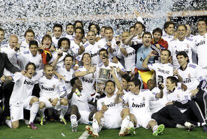 Los jugadores del Madrid disfrutan con el trofeo en sus manos.