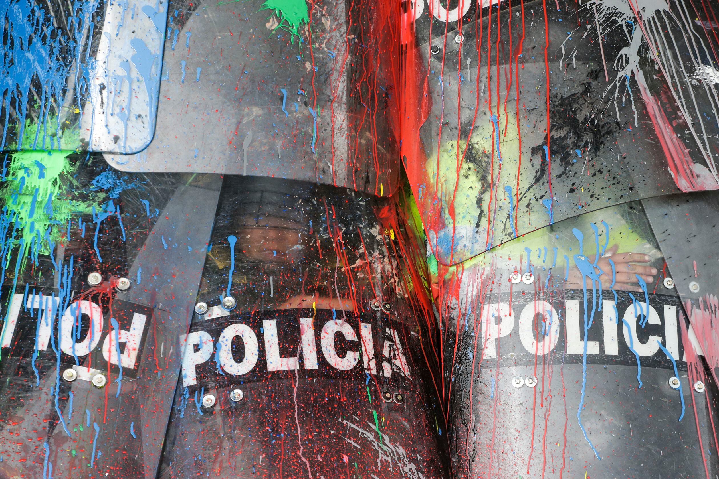 Escudos de la Policía Nacional manchados de pintura durante una protesta.