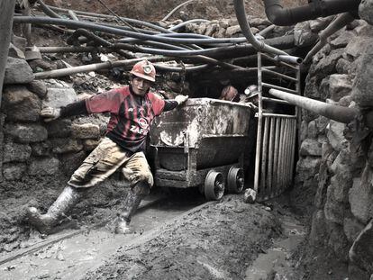 El minero Nelson Espinoza, de 33 años, arrastra un vagón junto a otros compañeros a la salida de un túnel de la mina.