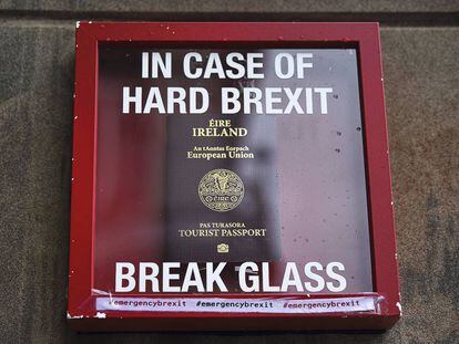 Un pasaporte irlandés junto al Parlamento británico dentro de una caja con el aviso:
