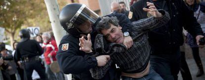 Efectivos de la policía detienen a uno de los asistentes a la protesta.