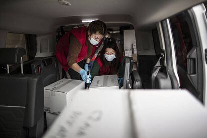 Madre e hija revisan las cajas en la furgoneta.