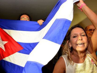Un grupo de personas porta una bandera cubana.