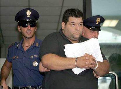 Achille Marmo, hermano de una de las víctimas de la matanza de Duisburgo, escoltado por dos policías en Reggio Calabria tras su detención.