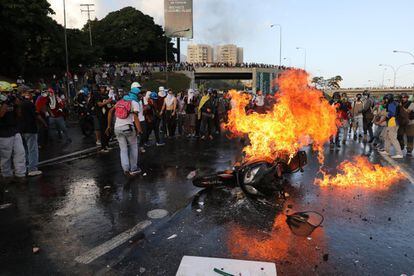 Manifestantes queman una moto durante una protesta en contra del Gobierno de Nicolás Maduro, en Caracas.