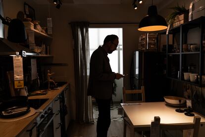 A man scans the labels of some furniture with his cell phone.