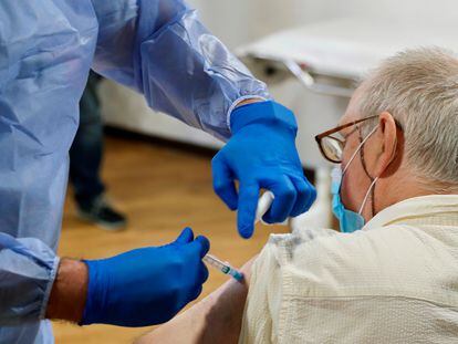 Una sanitaria pone la vacuna contra la covid-19 a un residente de un geriátrico público.