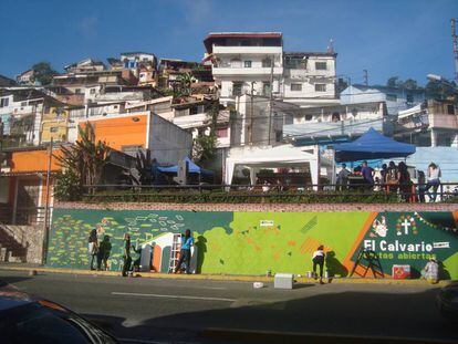 Artistas locales pintan el mural de entrada del barrio durante las jornadas de sus puertas abiertas.
