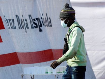 Un migrante camina hacia una carpa de la Cruz Roja después de desembarcar de un barco de la Guardia Costera española, en el puerto de Arguineguín, el pasado miércoles.