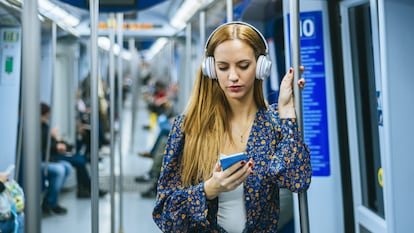 Auriculares grandes de color rosa con un cable sobre un fondo azul. imagen  de vista superior