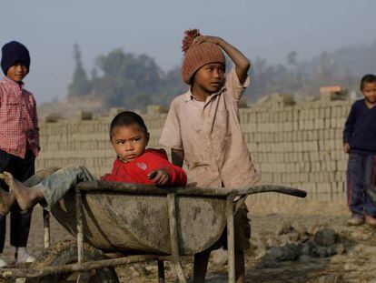 Niños trabajan cargando bloques para la construcción en Nepal.