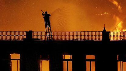 Un bombero hace frente a las llamas que destruyen un edificio en el centro de Lisboa.