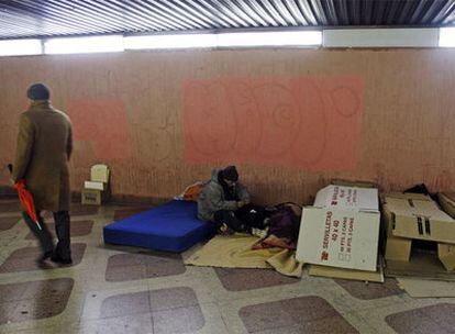 Un grupo de indigentes se refugia del frío en un túnel peatonal bajo la calle de Alcalá de Madrid.