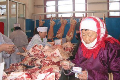 Una mujer hace la compra en un mercado de carne de Ulan Bator.