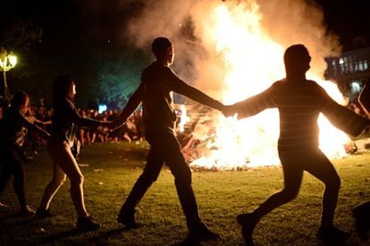 Un grupo de gente celebra la noche de San Juan alrededor de una hoguera en Mundaka.