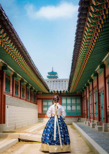 Mujer coreana ataviada con un traje típico en el interior de una pagoda.