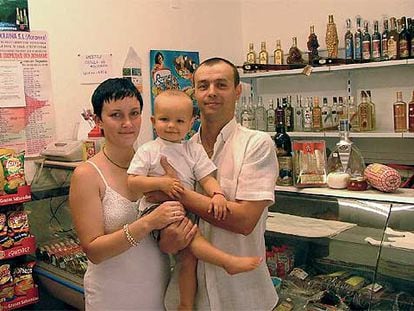 Victoria Plugaru, su marido Alexandru Plamadeala y su hijo, en la tienda de productos rusos Maxim, en Granada.