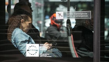 Una pasajera utiliza su tel&eacute;fono m&oacute;vil en un autob&uacute;s p&uacute;blico de Barcelona