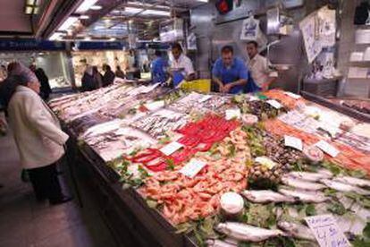 Una mujer realiza sus compras en la pescadería de un mercado madrileño. EFE/Archivo