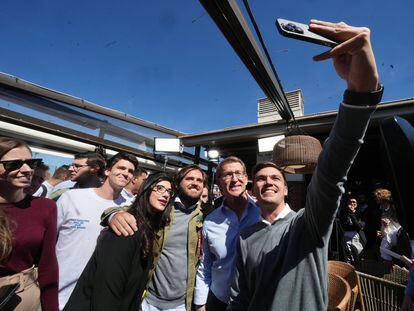 El presidente del PP, Alberto Núñez Feijóo, posa para una foto con jóvenes en un acto de vivienda en Madrid.