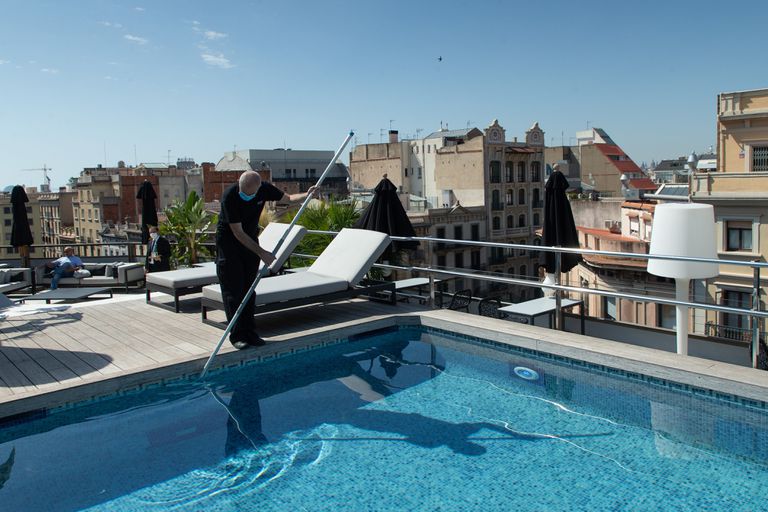 A worker performs maintenance tasks in the swimming pool of a luxury hotel in Barcelona, ​​last summer.