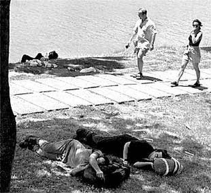 Dos jóvenes descansaban ayer a la sombra de los árboles junto al Guadalquivir en Sevilla.