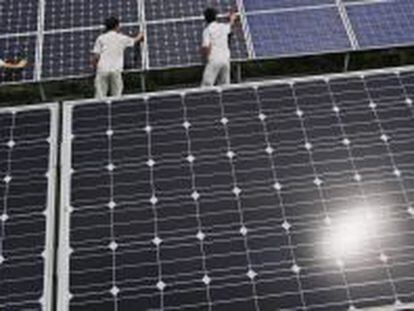Trabajadores colocan paneles solares en Baoding (China). 