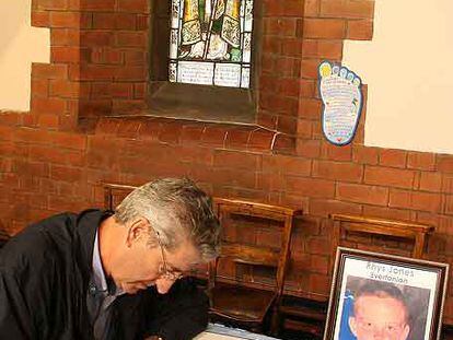 Un hombre firma en el libro de condolencias por la muerte de Rhys Jones.