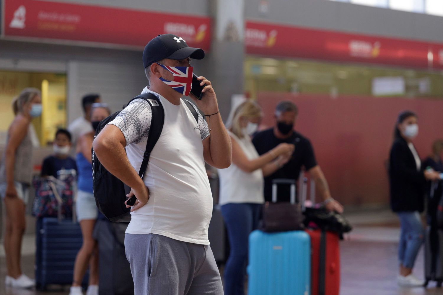 Viajeros con destino al Reino Unido hacen cola para facturar en el aeropuerto de Tenerife Sur, en Granadilla de Abona, Tenerife.